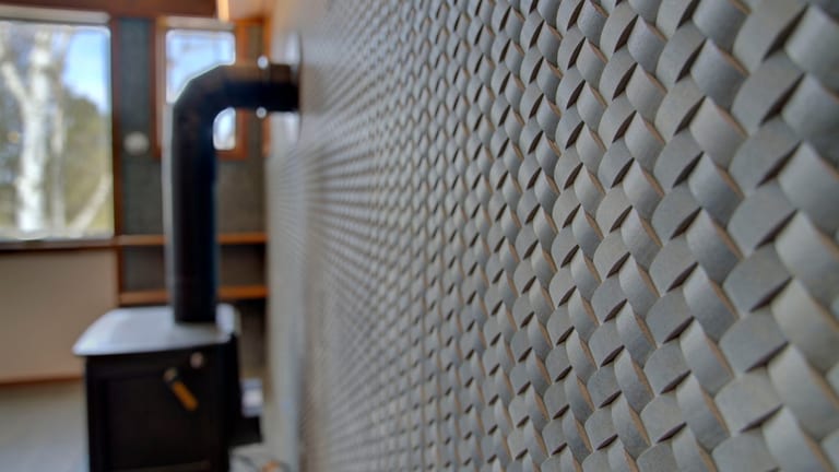 Basket-weave tile wall behind a wood stove in a remodeled home