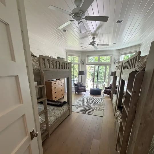 Kids’ room with wood bunk beds and a vaulted white ceiling